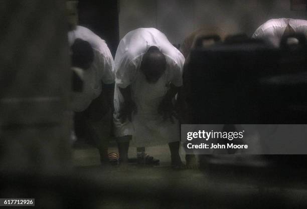 Prisoners bow during evening prayers at the "Gitmo" detention center on October 22, 2016 at the U.S. Naval Station at Guantanamo Bay, Cuba. The U.S....