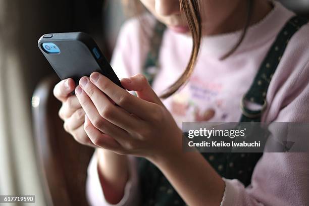 kid looking at smartphone - child mobile phone stock-fotos und bilder