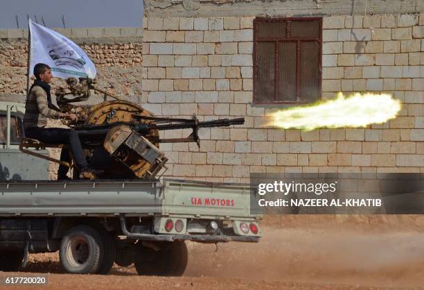 Fighter from the Free Syrian Army fires an anti-aircraft machine gun mounted on a vehicle deployed during fighting against Islamic State group...