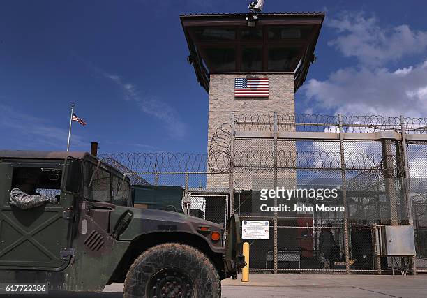 Humvee passes the guard tower guard tower at the entrance of the U.S. Prison at Guantanamo Bay, also known as "Gitmo" on October 23, 2016 at the U.S....