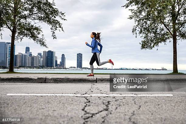 woman working out outdoor in the city. - chicago lifestyle stock pictures, royalty-free photos & images