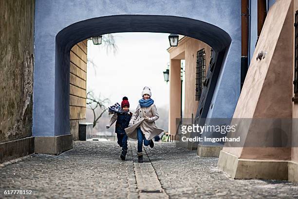 kinder zu besuch in warschau - laufen in der altstadt hinter der straße - daily life in warsaw poland stock-fotos und bilder