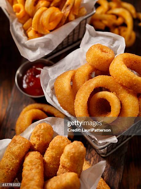 baskets of onion rings, curly fries and cheese sticks - frituur stockfoto's en -beelden