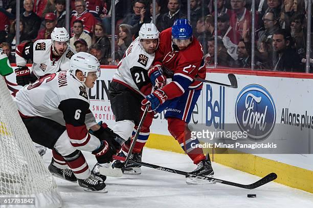 Jakob Chychrun of the Arizona Coyotes tries to get possession of the puck while teammate Jamie McBain defends against Alex Galchenyuk of the Montreal...