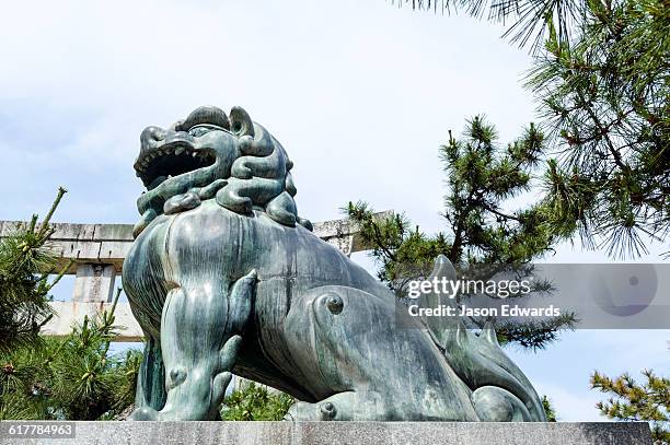 a komainu lion statue guarding a shrine from evil sprits. - miyajima stock pictures, royalty-free photos & images