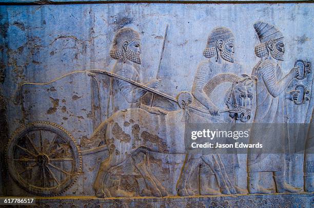 carved bas reliefs depict envoys of the subject nations of persia bringing gifts to the king. - chariot stockfoto's en -beelden
