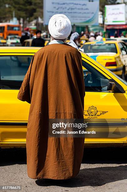 a member of the clergy wearing a turban and a woven cloak getting into a taxi. - tunic bildbanksfoton och bilder