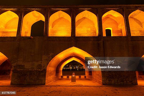 light cascades from iwans lining the khaju bridge at night during nowruz iranian new year. - isfahan 個照片及圖片檔