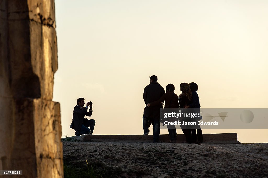 Iranian tourists make a family photograph at the four tombs belonging to Achaemenid kings carved from the rock face at the archeological site of Naqsh-e Rustam also known as the Necropolis.