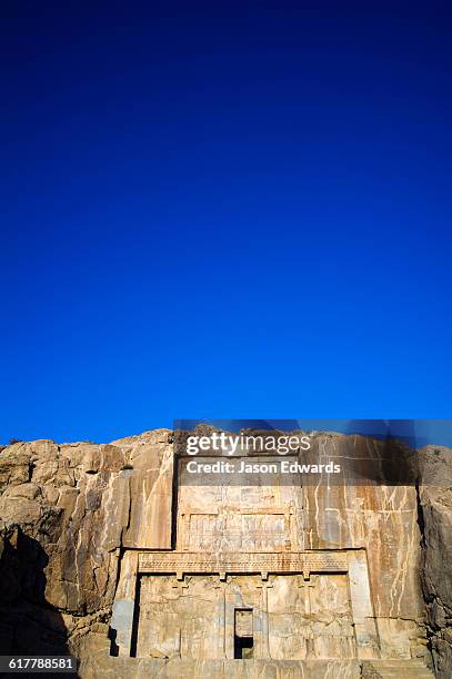 the tomb of artaxerxes iii carved into a cliff face at persepolis. - artaxerxes stock pictures, royalty-free photos & images