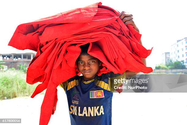 Bangladeshi child laborer carries dry leather on his head in Dhaka, Bangladesh, on October 22, 2016. Bangladeshi laborer dries out unprocessed...
