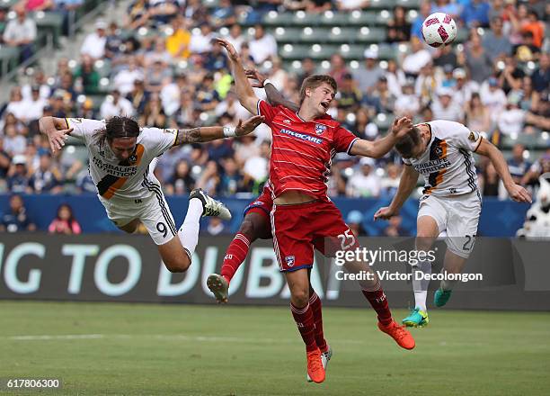 Alan Gordon and Dave Romney of the Los Angeles Galaxy and Walker Zimmerman and Atiba Harris of FC Dallas vie for the ball during their MLS match at...