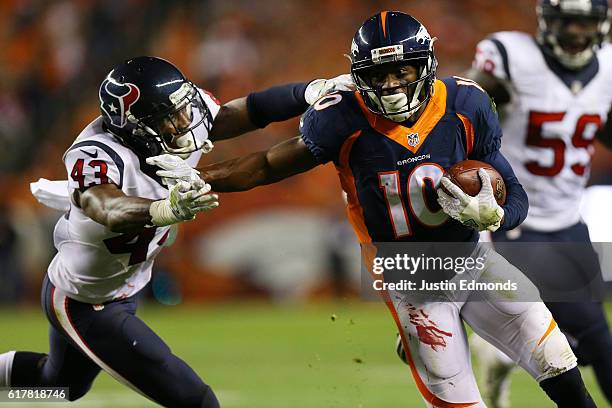 Wide receiver Emmanuel Sanders of the Denver Broncos stiff arms defensive back Corey Moore of the Houston Texans in the second quarter of the game at...