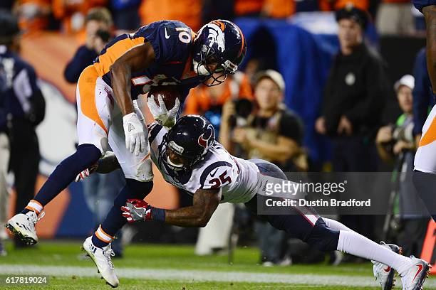 Wide receiver Emmanuel Sanders of the Denver Broncos is tackled after catching a pass by cornerback Kareem Jackson of the Houston Texans at the...