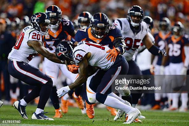 Wide receiver Braxton Miller of the Houston Texans is tackled by linebacker Dekoda Watson of the Denver Broncos in the first half of the game at...