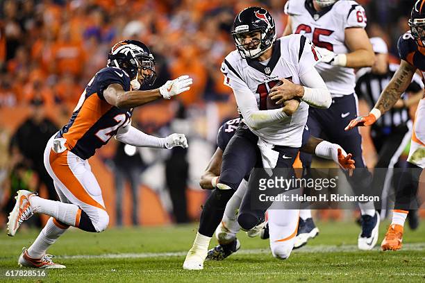 Brock Osweiler of the Houston Texans scrambles out of the pocket as Chris Harris of the Denver Broncos and Brandon Marshall pursue during the third...