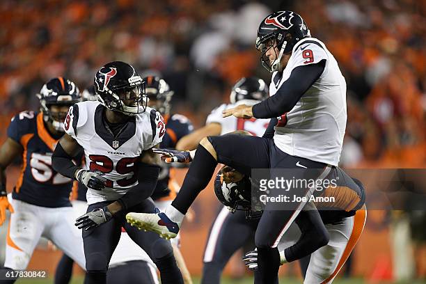 Shane Lechler of the Houston Texans is lit up by Shaquil Barrett of the Denver Broncos after punting during the fourth quarter on Monday, October 24,...