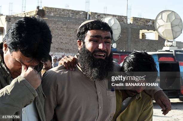 Pakistani relatives mourn the loss of family members in Quetta on October 25 after an overnight militant attack on the Police Training College in the...
