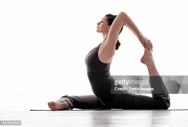 side-view of young woman practicing yoga - contortionist photos et images de collection