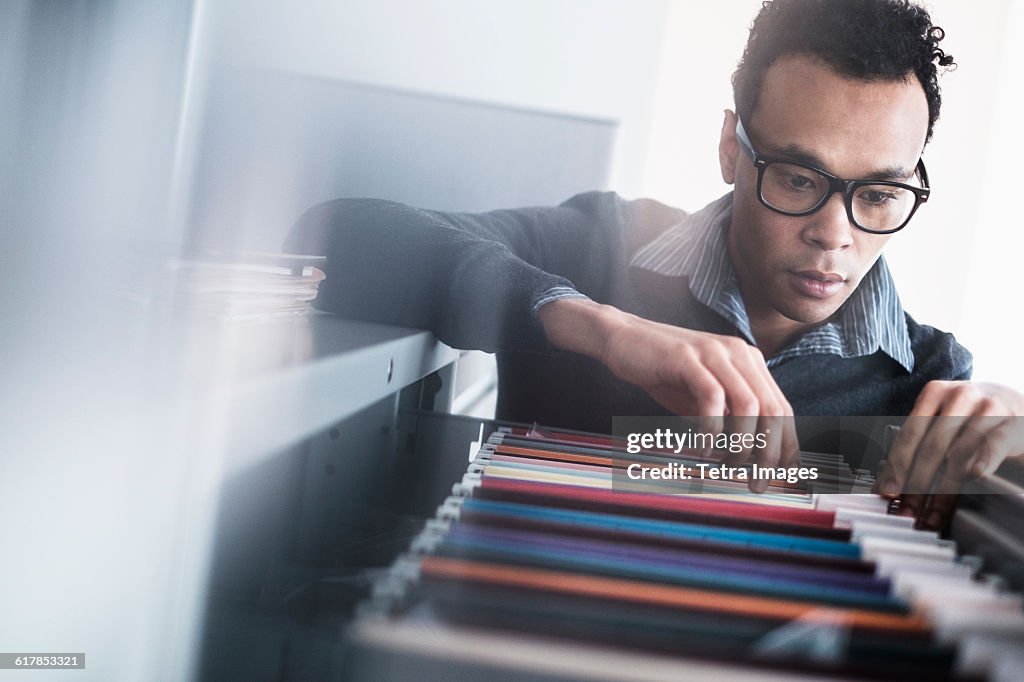Man Using File Mid Adult Man Searching For Files In Filing Cabinet High-Res Stock ...