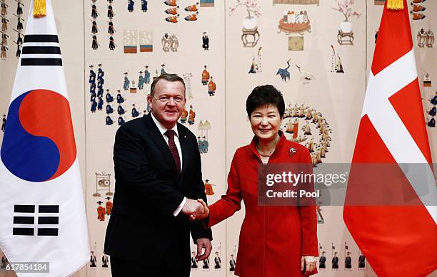 Danish Prime Minister Lars Lokke Rasmussen shakes hands with South Korean President Park Geun-Hye before their meeting at the presidential blue house...