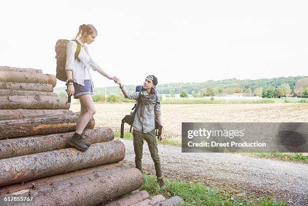 "young couple preparing to continue their hiking on wood pile, bavaria, germany" - holzstapel stock-fotos und bilder