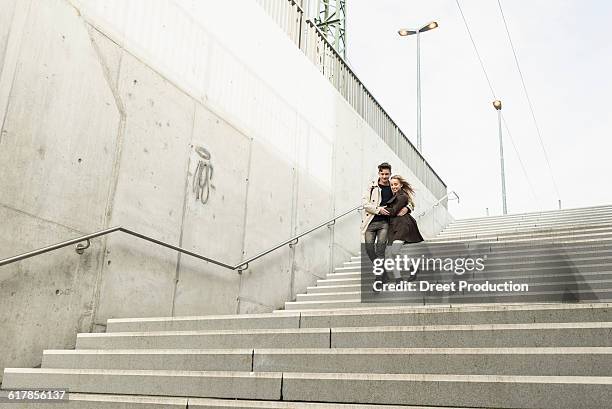 "young couple walking down the stairs hugging each other, munich, bavaria, germany" - munich street stock pictures, royalty-free photos & images