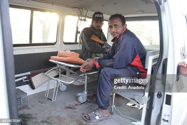 Pakistani police and a man are seen in an bloodstained ambulance outside the Balochistan Police Training College in Quetta on October 24 after...
