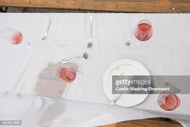 "high angle view of plate with remains and half full glasses of red wine on picnic table, bavaria, germany" - messy table after party 個照片及圖片檔