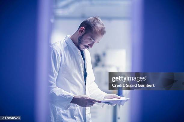 "young male scientist looking at report in an optical laboratory, freiburg im breisgau, baden-w��rttemberg, germany" - medical research paper stock pictures, royalty-free photos & images