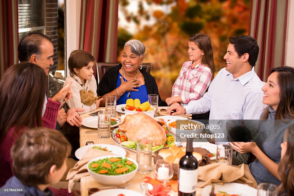 Multi-ethnic family enjoying Thanksgiving dinner at grandmother's home.