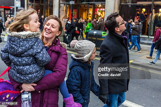 young family sightseeing and shopping at christmas markets - oxford street london stockfoto's en -beelden