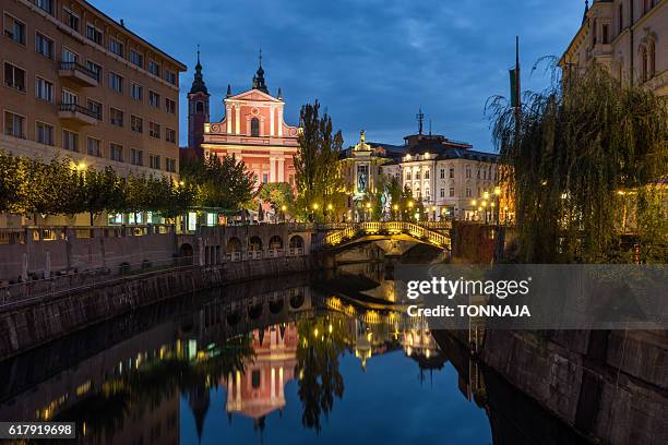 slovenia, ljubljana, illuminated buildings and ljubljanica river - ljubljana stockfoto's en -beelden