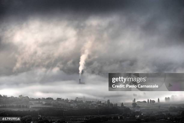 smokestack emerging from fog in terni, italy - factory smog stock pictures, royalty-free photos & images