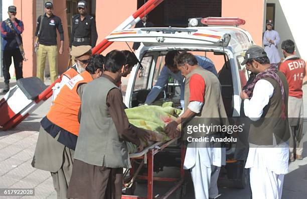 Pakistani emergency workers carry a victim in Quetta, Quetta on October 25 after militants attacked the training college. At least 61 cadets and...