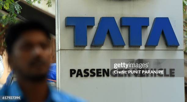 An Indian man walks past a signage of a Tata Motor's showroom in Mumbai on October 25, 2016. - Industrialist Ratan Tata sensationally returned to the...
