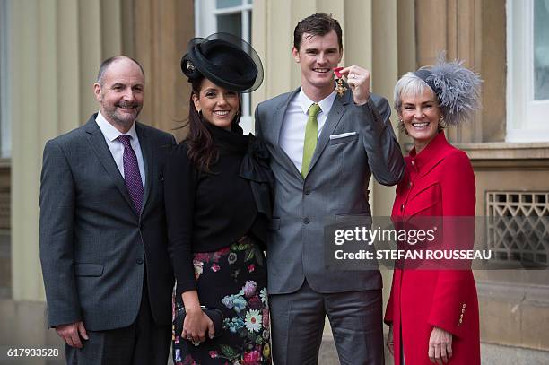 British tennis player Jamie Murray poses with his father William , wife Alejandra Gutierrez and mother Judy at Buckingham Palace in London after he...