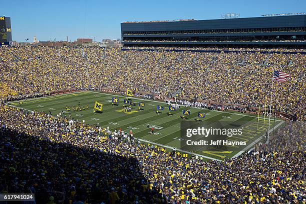 Aerial view of Michigan cheerleaders on field with flags spelling out MICHIGAN before game vs Penn State at Michigan Stadium. Ann Arbor, MI 9/24/2016...