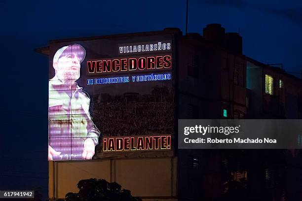 Luminous or Luminic electric billboard of Fidel Castro shining brightly in the dark of night.