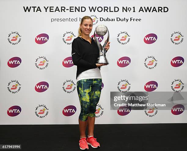 Angelique Kerber of Germany poses with the DDF Year-End World No.1 trophy during day 3 of the BNP Paribas WTA Finals Singapore at Singapore Sports...