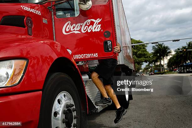 An employee climbs into the driver seat of a Coca-Cola Co. Delivery truck in Miami Beach, Florida, U.S., on Monday, Oct. 24, 2016. The Coca-Cola Co....