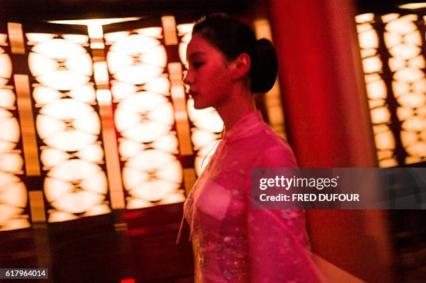 Model walks backstage during the first show by the Chinese luxury brand Ne Tiger during the China Fashion Week in Beijing on October 25, 2016. / AFP...