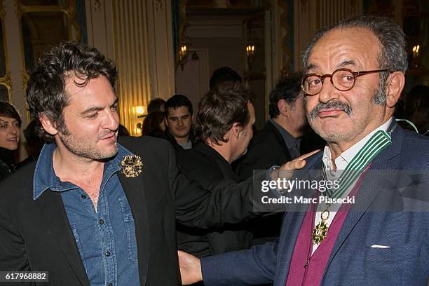 Matthieu Chedid and his father musician Louis Chedid poses after receiving the medal of 'Commander of the Order of Arts and Letters' at Ministere de...