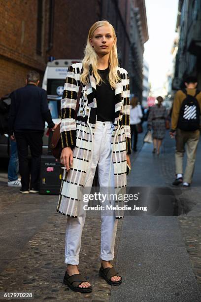 Danish model Frederikke Sofie wears a black and white Freya Dalsjø jacket black top, white jeans, a brown Celine purse, and green sandals after the...