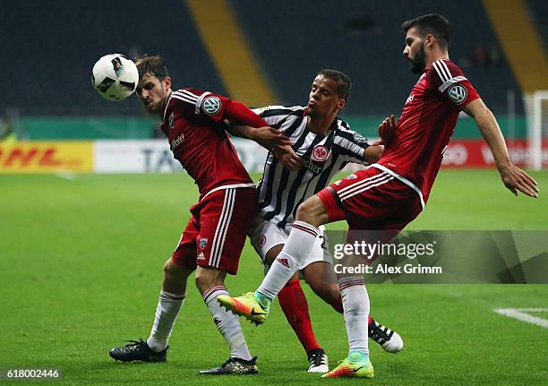 Timothy Chandler of Frankfurt is challenged by Pascal Gross and Anthony Jung of Ingolstadt during the DFB Cup Second Round match between Eintracht...