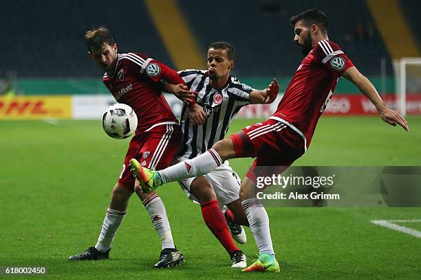 Timothy Chandler of Frankfurt is challenged by Pascal Gross and Anthony Jung of Ingolstadt during the DFB Cup Second Round match between Eintracht...