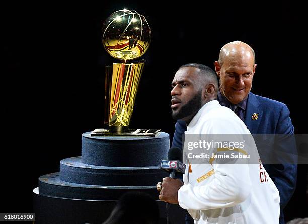 LeBron James of the Cleveland Cavaliers speaks in front of the Larry O'Brien Trophy after receiving his championship ring before the game against the...