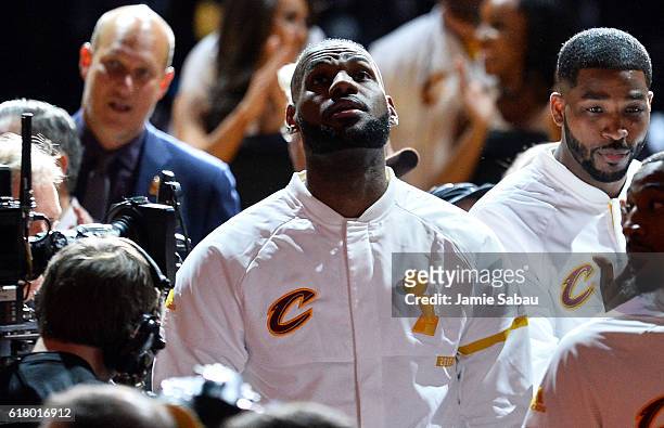 LeBron James of the Cleveland Cavaliers watches as the championship banner is raised before the game against the New York Knicks at Quicken Loans...