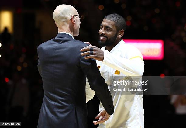 Kyrie Irving of the Cleveland Cavaliers shakes hands with NBA commissioner Adam Silver as he receives his championship ring before the game against...