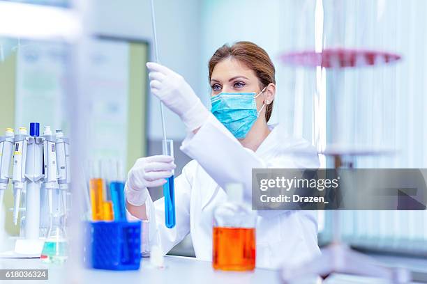 científico en laboratorio utilizando mediciones para nuevas soluciones - fábrica farmacéutica fotografías e imágenes de stock